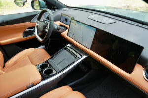 Interiör av en bil med utsikt över ratt och två digitala skärmar på instrumentpanelen.
