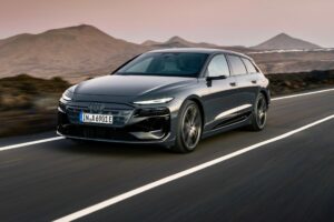 Framifrån vy av Audi A6 E-Tron på en landsväg.