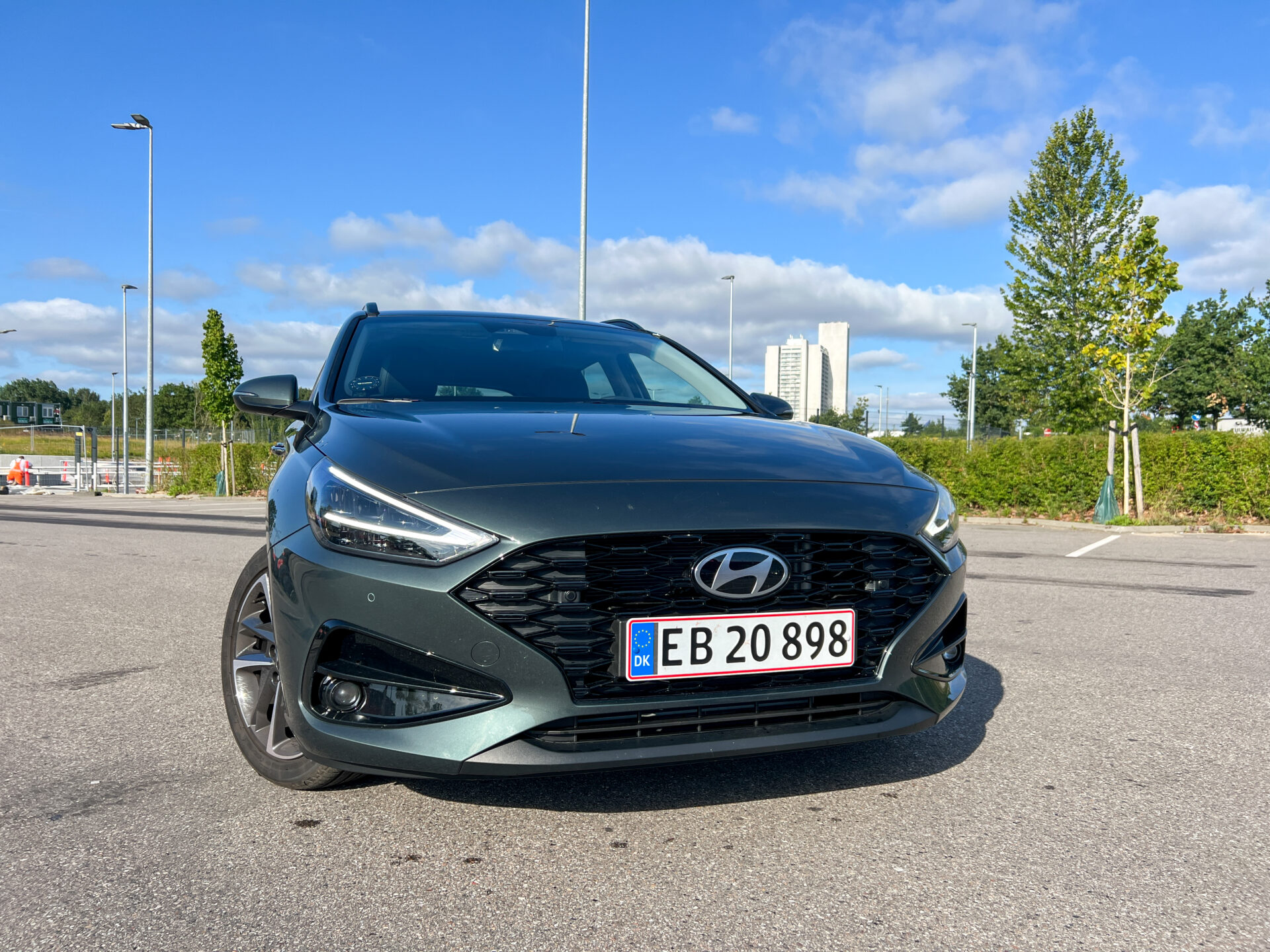 Framsidan av en grön Hyundai i30 med registreringsskylten EB 20 898, parkerad på en asfalterad yta.