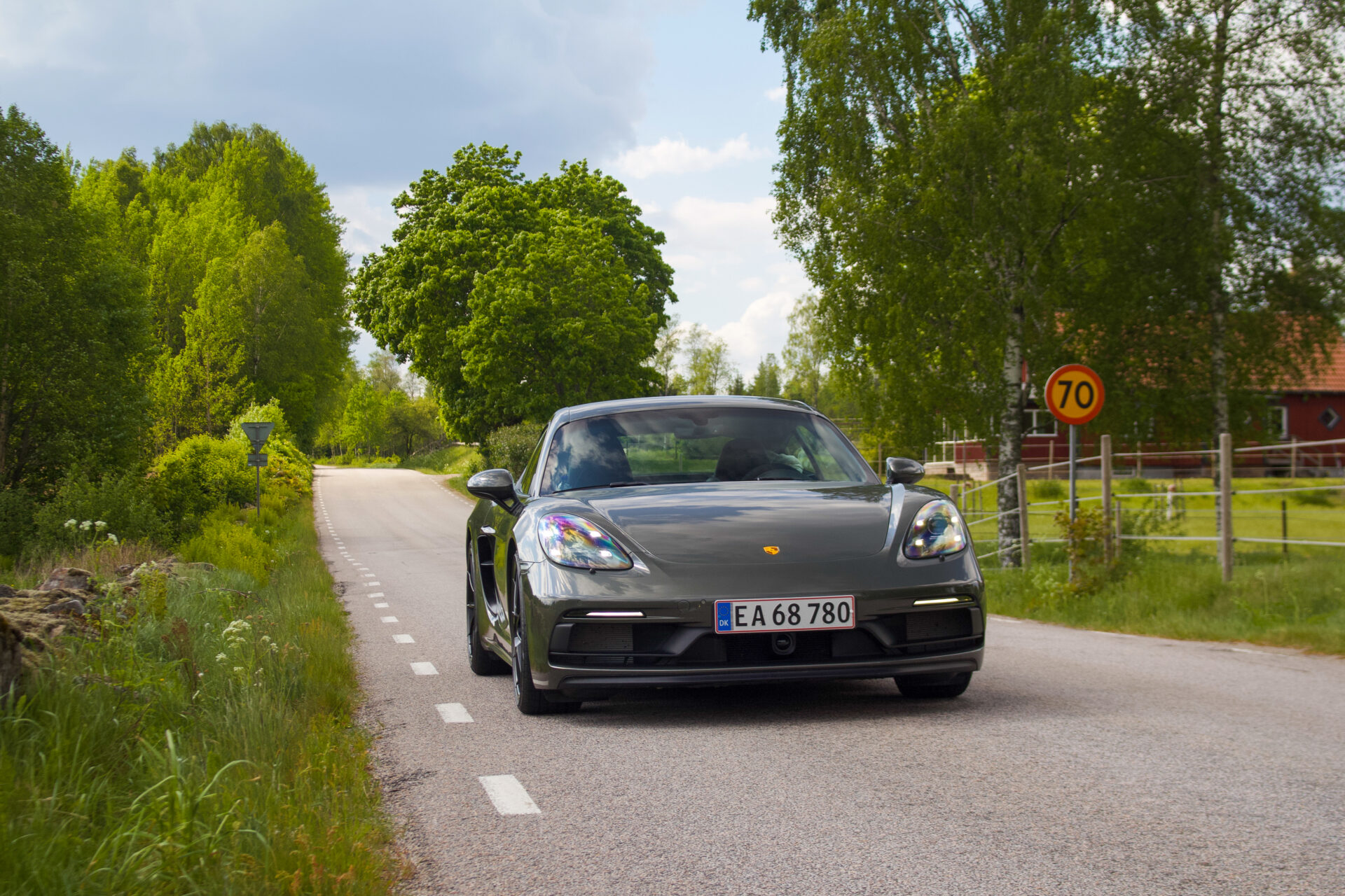 Svart porsche cayman körandes på landsväg