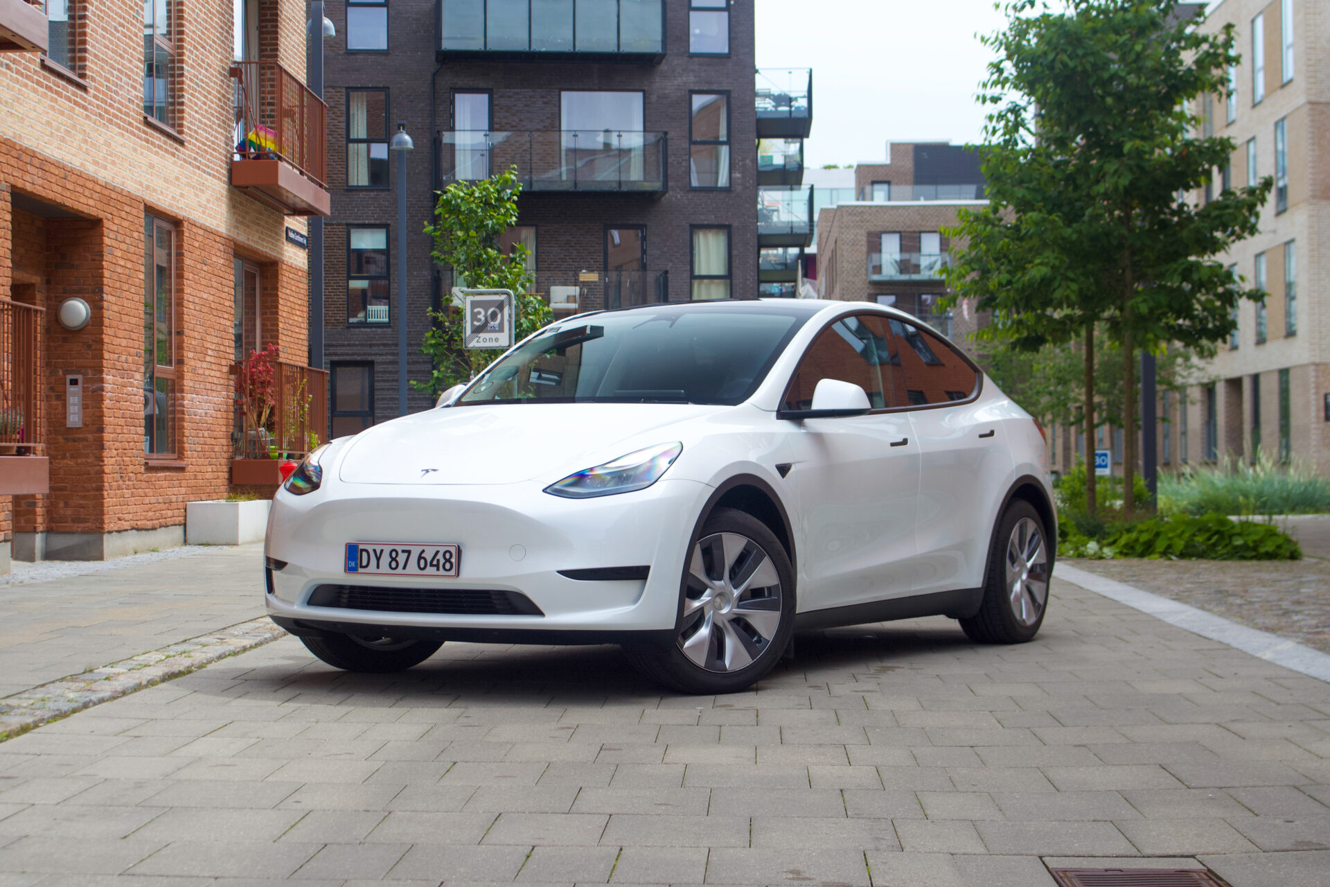 Vit tesla model Y parkerad på gatan.